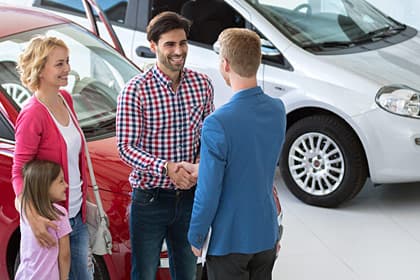 photo of family buying car at automobile dealership